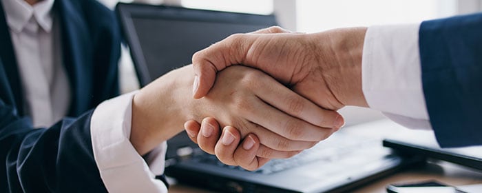Handshake between two professionals representing affordable e-commerce website design services in Pakistan.